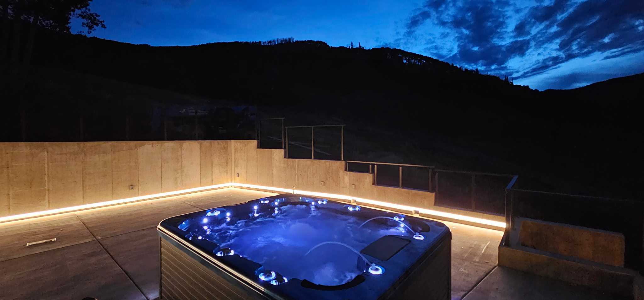 Deck-side ten-person hot tub with mountain views